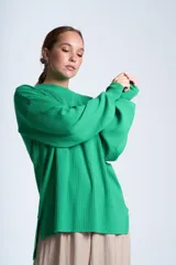 Sweater azul eléctrico de punto acanalado, con cuello redondo y mangas largas. Corte holgado con aberturas laterales.