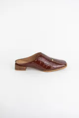 Zueco de cuero con textura tipo croco en color negro, con punta almendrada y taco bajo de madera.