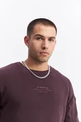 Sweater de algodón con textura acanalada, cuello redondo, mangas largas con hombros caídos y calce relajado. Presenta un logo bordado sutil en el pecho.