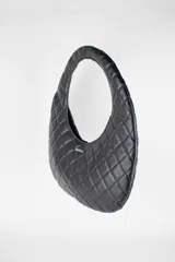 Cartera acolchada negra de silueta ovalada con asa circular integrada y diseño matelassé en rombos.