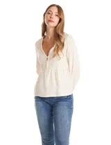 Blusa de algodón color beige con escote en V, cierre frontal con botones y detalles de puntilla en el frente. Presenta mangas largas amplias con puños elastizados y un diseño con bordados sutiles.