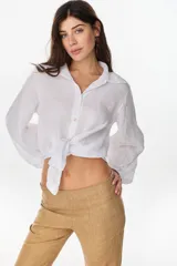 Camisa de lino italiano color blanco, con cuello camisero, cierre frontal con botones y mangas largas abullonadas estilo globo.