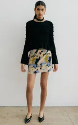 Minifalda con estampado abstracto en tonos beige, azul, amarillo y negro, con pretina elástica.