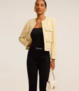 Pantalón flare negro de punto roma con detalle metálico en la cintura y cierre delantero.