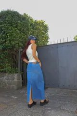 Falda larga de jean azul claro, con tajo trasero, pretina con doble botón y cierre metálico.