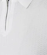Polo de manga corta para hombre, color blanco, con cuello polo y cierre frontal de cremallera. Presenta una textura tejida sutil en toda la prenda.
