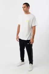 Pantalón de jogging negro con una franja vertical blanca a los costados y logo de la marca en la pierna izquierda.