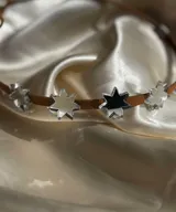 Gargantilla de cuero marrón con dije de estrellas espejadas.