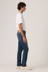 Jeans de corte slim fit en denim azul con lavado clásico, diseño de cinco bolsillos y cierre frontal con botones.