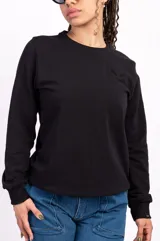 Buzo negro de algodón de corte clásico con cuello redondo y mangas largas. Tiene un pequeño logo bordado en el pecho.