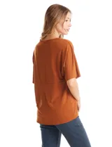 Blusa de silueta fluida con escote en V, manga japonesa corta y costura central vertical en el frente. Confeccionada en tejido de punto con acabado mate, presenta un diseño con largo asimétrico, siendo más larga en la espalda.