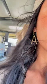 Arete tipo argolla de bronce con dije colgante de letra "A" con textura de bambú o ramas. Se vende por unidad.