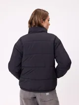 Campera puffer reversible de la marca Rusty, con diseño capitoneado. Presenta cuello alto, cierre frontal completo y logo bordado en el pecho. El interior es de un tono contrastante.