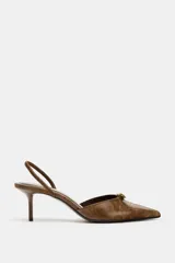 Zapato destalonado de tacón fino con acabado efecto desgastado, punta fina y detalle de hebilla metálica en la parte delantera. Cuenta con tira trasera ajustable.
