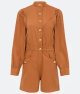 Mono corto color ladrillo, de sarga de algodón, con cuello mao, mangas abullonadas largas, cierre frontal con botones dorados, bolsillos laterales y cintura marcada.