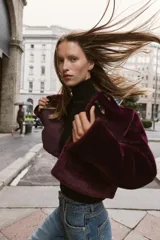 Chaqueta de cuello redondo y manga larga con tejido exterior efecto pelo e interior efecto ante. Presenta bolsillos delanteros de vivo y cierre frontal con alamares metálicos.