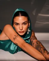 Minivestido satinado color verde esmeralda, con capucha, espalda descubierta y drapeado en la falda.