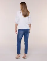 Blusa Liv Los Angeles de color blanco, confeccionada con torso de modal y mangas tres cuartos con detalles de bordado calado. Presenta cuello redondo con apertura central y cierre frontal de botones.