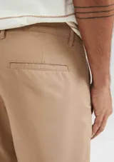 Bermuda de corte recto estilo chino, confeccionada en lino, con ruedo doblado y cierre frontal.