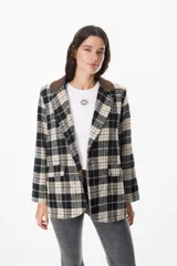 Blazer de corte recto con estampado de cuadros en tonos negro, beige y verde. Presenta cuello de solapa en pana marrón, cierre frontal con botones y bolsillos laterales con solapa.