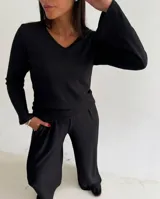 Remera de lanilla con textura acanalada, escote en V y mangas largas estilo oxford. Presenta un diseño ajustado al cuerpo.