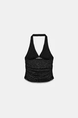 Top halter de tejido semitransparente con estampado de lunares plumeti, escote en pico y detalle de frunces en los laterales.