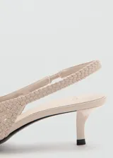 Zapato destalonado color beige, con diseño trenzado, punta fina y tacón kitten.