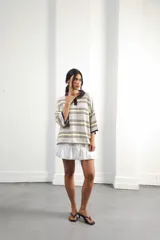 Remera rosa con rayas horizontales azul marino y bordó, cuello tipo polo marrón con botones y mangas cortas amplias.