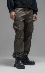 Pantalón cargo de corte regular confeccionado en textil técnico pesado color chocolate. Presenta cintura elástica con cordón de ajuste, dos bolsillos laterales en la cintura y dos bolsillos cargo de gran tamaño. Incluye elásticos con tancas en los tobillos para regular la apertura de la pierna.