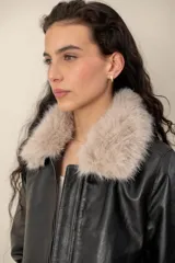 Campera de cuero negro con cuello desmontable de piel sintética en color celeste, cierre frontal y bolsillos laterales.