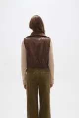 Chaleco cropped de eco-cuero color marrón, con cierre frontal, cuello solapa y bolsillos con cierre en el pecho.