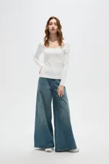 Top de manga larga color blanco, con cuello redondo amplio y ajuste al cuerpo.