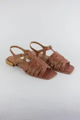 Sandalias de cuero color marrón, con tiras entrelazadas en la capellada, talón cerrado con tira ajustable mediante hebilla y taco bajo cuadrado.