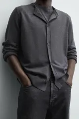 Cárdigan de punto con lana, de corte regular fit, cuello redondo y manga larga. Presenta cierre frontal con botones y acabados en rib en puños y bajo.