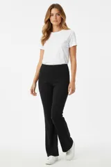 Calza negra de tiro medio, corte oxford (acampanado en la parte inferior), confeccionada en tela de algodón.