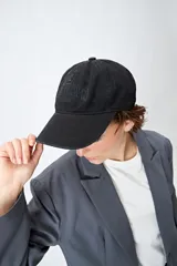Gorra de algodón negra con diseño clásico tipo baseball y bordado frontal en relieve con la palabra "Brooklyn". Cuenta con visera curva y correa regulable con hebilla metálica en la parte posterior.