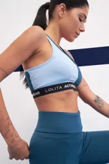 Top deportivo bicolor azul y rosa con breteles finos y banda elástica con logo de la marca.