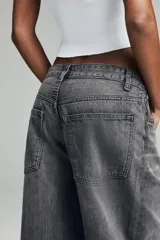 Jeans de mujer color beige claro, tiro medio, estilo balloon baggy con pierna ancha y largo completo. Presenta costuras visibles y un lavado que le da un aspecto desgastado.