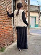 Pantalón tipo palazzo de tiro alto, confeccionado en plush de algodón con textura suave. Presenta un diseño amplio y fluido, con bolsillos laterales y una faja ancha en la cintura que brinda ajuste y comodidad.