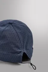 Gorra deportiva de tejido técnico ligero en color azul marino, con visera corta y paneles laterales perforados para mayor ventilación. Presenta logos bordados a tono en el frente.