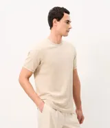 Remera de algodón peruano color beige con textura de rayas verticales, cuello redondo y mangas cortas.