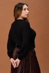 Sweater de punto fino en color marrón, con cuello redondo y mangas largas. Presenta un diseño básico y minimalista con un corte a la cintura.