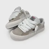 Zapatillas de skate Vision Street Wear de color beige y gris, confeccionadas en gamuza y lona, con cordones gruesos blancos y suela de goma blanca.