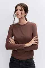 Remera de manga larga en color marrón, con cuello redondo y corte ajustado al cuerpo.