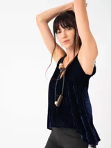 Top negro de terciopelo con breteles finos regulables y escote en V. La parte trasera es más larga que la delantera.