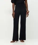 Pantalón de corte recto confeccionado en tejido de punto con cintura elástica. Presenta un diseño básico y versátil de tiro medio.