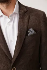 Blazer de corte slim fit confeccionado en pana de textura suave, con cierre frontal de dos botones, solapas clásicas y bolsillos laterales con solapa.