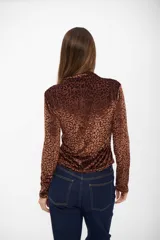 Top de manga larga con cuello alto, confeccionado en tejido aterciopelado con estampado animal print de leopardo en tonos marrones.