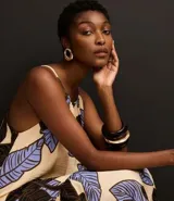 Vestido evasê largo midi de frente única, confeccionado en viscosa, con estampado de hojas en tonos beige, negro y celeste.