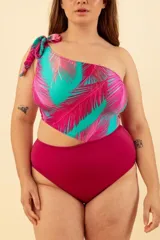 Malla enteriza de lycra con estampado de hojas de palmera en tonos turquesa y fucsia. Diseño asimétrico con un solo hombro y abertura lateral.